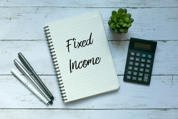 Business and finance concept. Top view of plant,calculator,pen and notebook written with Fixed Income.
