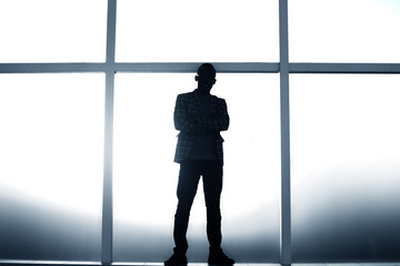 background image. businessman standing near the window