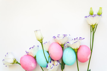 Easter eggs and spring flowers narcissi on white background