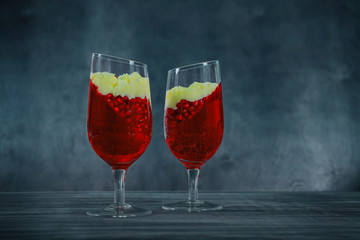 Panna cotta dessert with pomegranate seeds jelly on rustic wooden background. Holiday food concept.