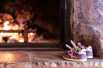 Wet purple sneakers drying on a fire pit