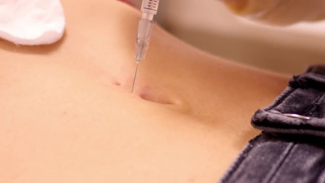 slow motion close view skilled master in sterile gloves checks skin sensitivity with syringe needle before piercing 