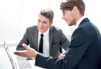Fototapeta premium two businessmen use a laptop in the office