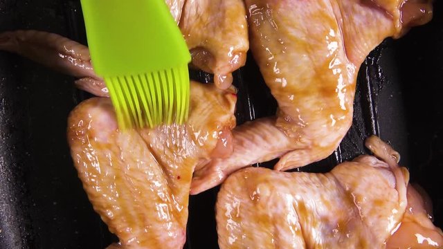 Cooking brush chicken wings on the grill pan with marinade top view