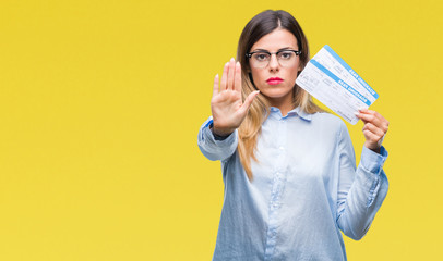 Young beautiful woman holding boarding pass over isolated background with open hand doing stop sign...