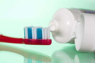 Toothpaste on a toothbrush on a white or colored background