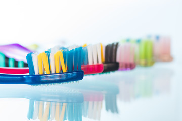 Several toothbrushes one by one next to the toothpaste
