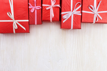 Red gift boxes on white wooden background. Copy space. Top view. Presents for Valentines day, Womens Day, anniversary or party.