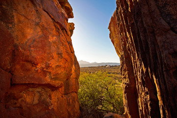 Fototapeta premium Cleft between red rocks overlooking valley
