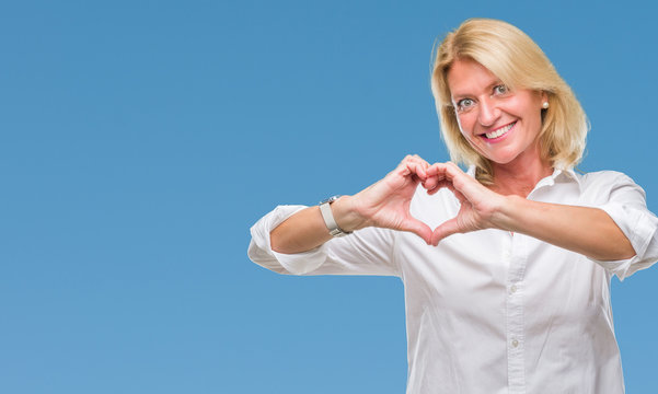 Middle age blonde business woman over isolated background smiling in love showing heart symbol and shape with hands. Romantic concept.