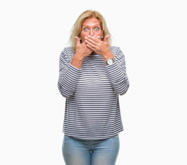 Middle age blonde woman over isolated background shocked covering mouth with hands for mistake. Secret concept.