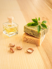 Bottles with cosmetic oil argan nuts. Cosmetic means. Food product. Jar with argan oil and handmade soap on the wooden background