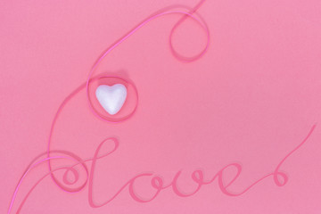  White Heart, word "love", ribbon on pink background. Love concept.