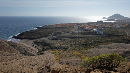 Elevated views from Pelada Mountain, locally known as Montana Pelada towards the windsurfing coastal town of El Medano and with Montana Roja at the far end, in Tenerife, Canary Islands, Spain