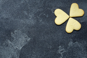 Obraz premium Shamrock cookies in the shape of a heart on a dark background.