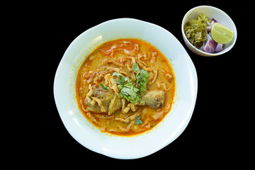 Khao Soi , Northern Thai Style Curried Noodle Soup with Chicken on black background