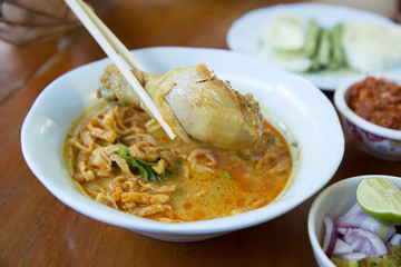 Khao Soi , Northern Thai Style Curried Noodle Soup with Chicken on wood background