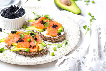 sandwich with avocado and salmon on a light background