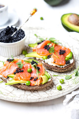 sandwich with avocado and salmon on a light background