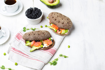 sandwich with avocado and salmon on a light background