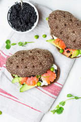 sandwich with avocado and salmon on a light background