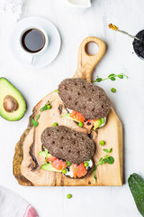 sandwich with avocado and salmon on a light background