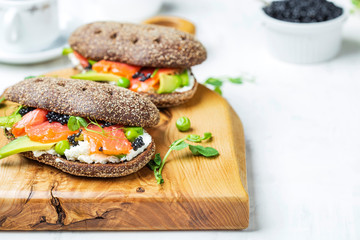sandwich with avocado and salmon on a light background