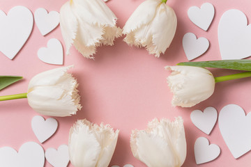 White flowers and hearts on a pastel pink background