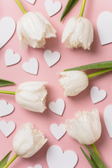White flowers and hearts on a pastel pink background