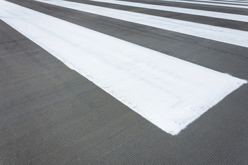 White stripes on grey asphalt, concrete marking.