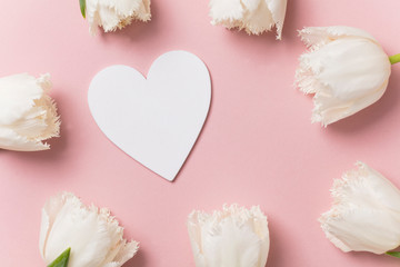 White flowers and hearts on a pastel pink background
