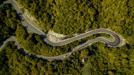 Aerial view of a curved winding road trough the forest. Sochi, South Russia.