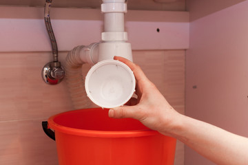 Clearing of blocked hammered polluted plastic U siphon for wash basin, sanitary devices, plumbing fixtures special means cleanser. Plumbing siphon. White plumbing siphon assembly © brizmaker