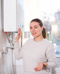 Young woman is standing near gas column in the kitchen