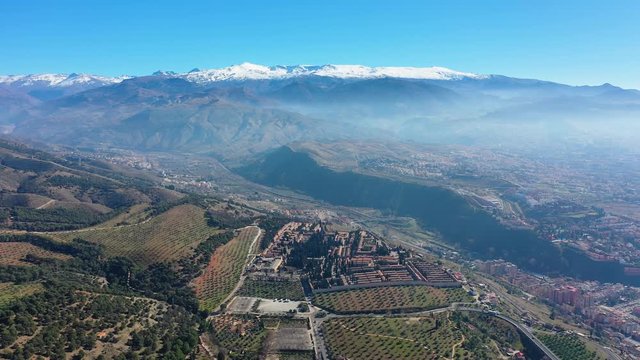 Aerial view of Sierra Nevada mountains in winter (from Granada), snowy peaks and blue sky - landscape panorama of Andalusia from above, Spain, Europe