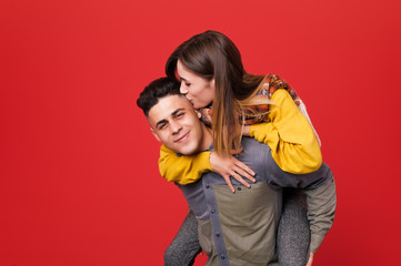 Cheerful lovely couple, man carrying young woman on his shoulders