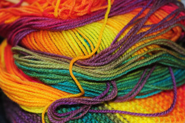 Skein of rainbow colored acrylic threads in free placement with selective focus