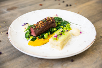 Beef meat with green peas, sweet potato mousse, roasted spinach and zucchini gratin