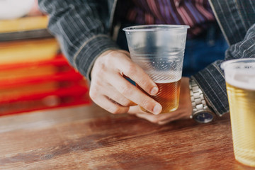 Fototapeta na wymiar man hand holds an incomplete glass of beer
