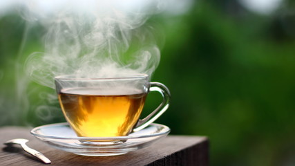 Tea cup with green leaf on the wooden table