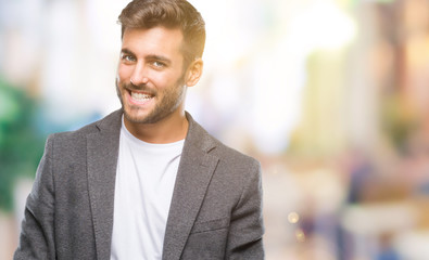Obraz premium Young handsome business man over isolated background looking away to side with smile on face, natural expression. Laughing confident.