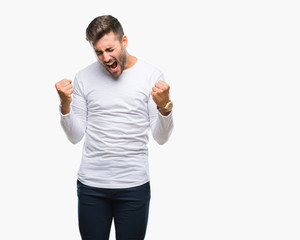 Young handsome man over isolated background very happy and excited doing winner gesture with arms raised, smiling and screaming for success. Celebration concept.