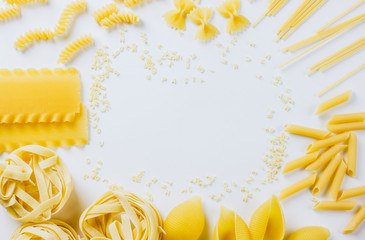 various uncooked pasta on white background.