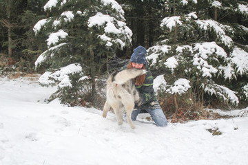 Husky dog runs in the woods with a girl. Play in the snow. Winter fun with a pet