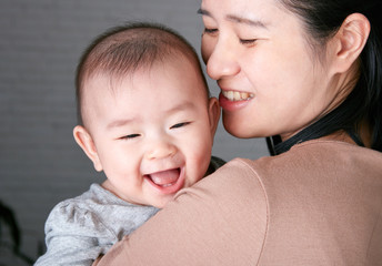 Asian young mother holding a baby in her arms
