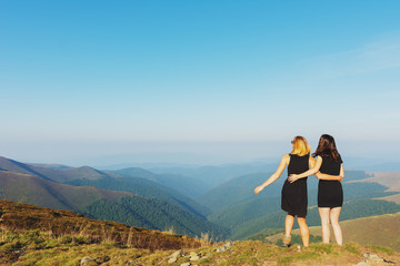 Naklejka premium Girls on a mountain ridge rest with tents.