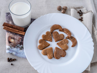 The glass of the milk with handmade's cakes on the plate near serviettes with  allspices and other spices on the natural tablecloth This picture have made by middleformat camera