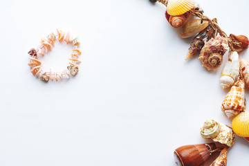 a necklace of pink shells in the shape of a heart.shell frame on white background.with copy space