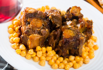 Braised oxtails with chickpeas on a white plate