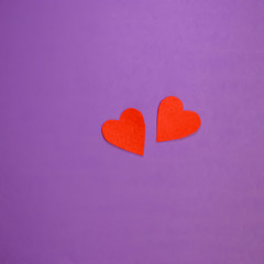 Two red decorative hearts on purple background. Valentine's Day Concept.